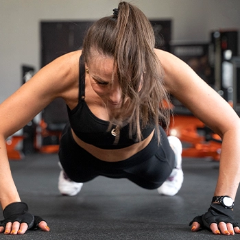 A woman performing burpees indoors