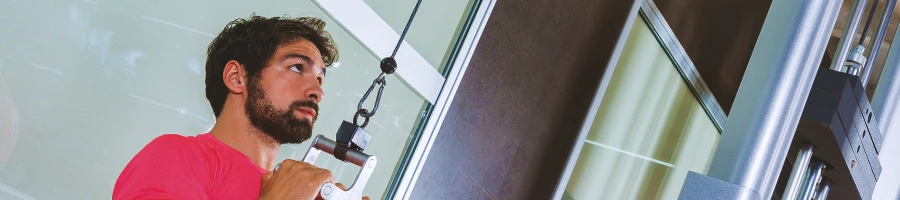 A person working out with a cable machine at a home gym