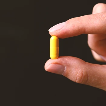 Close up shot of a person holding a supplement pill