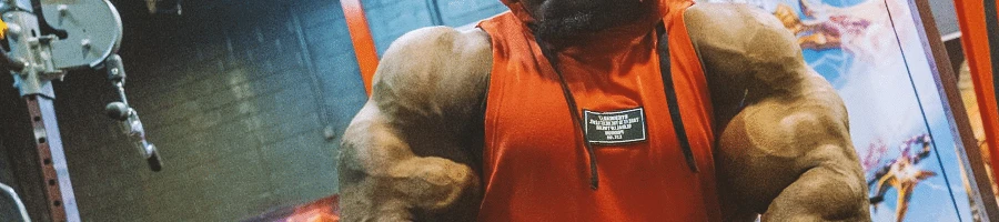 Kai Greene flexing his arm muscles in the gym