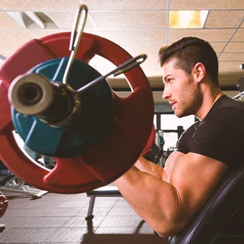 A person doing preacher curls in the gym