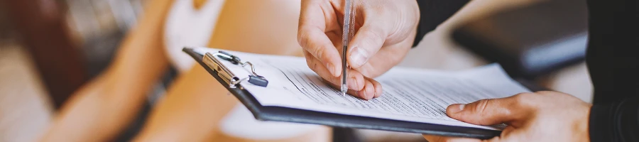 A gym coach writing down on a clipboard