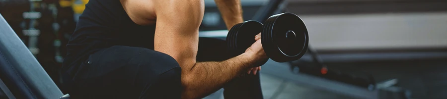 A person in the gym lifting weights for myo reps workout