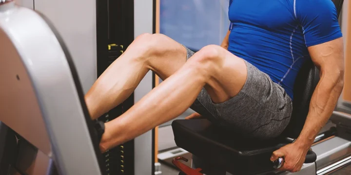 A person doing leg presses at a home gym machine