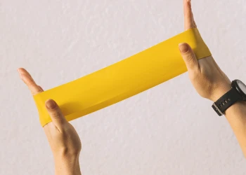 A person holding a resistance band at home