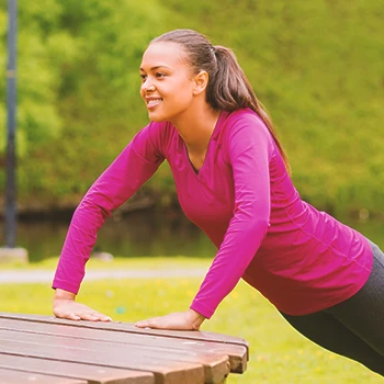 A person doing bench push ups at a park