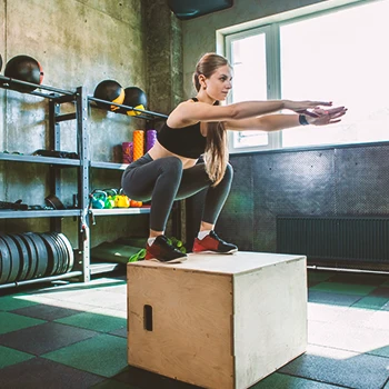 A person doing box squats in the gym