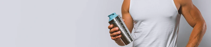 A buff male holding protein shake