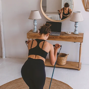 A woman working out with a resistance band in a home gym