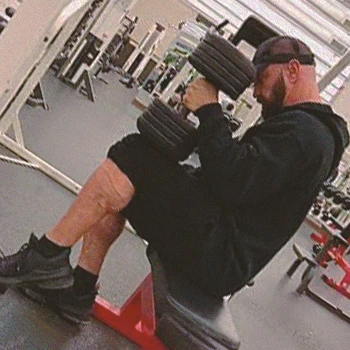 A person doing seated dumbbell calf raises