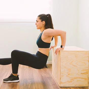 A person doing tricep dips with a box
