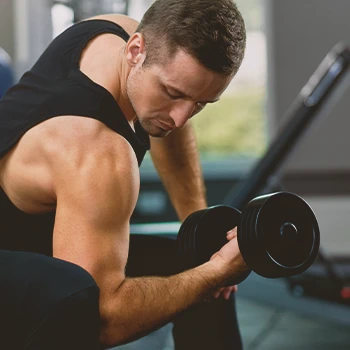 A person working out his shoulder and arms in the gym