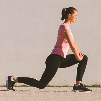 A person doing walking lunges outside