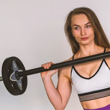 A woman working out with a budget barbell in her home gym
