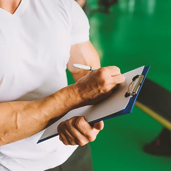 A gym coach writing down workout principles