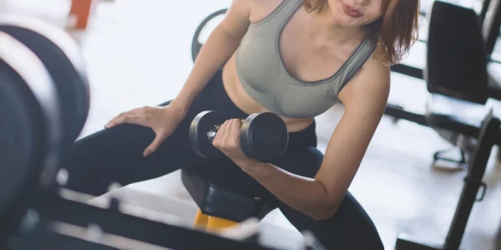 A person at a home gym working out with dumbbells