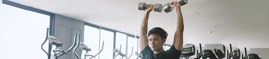 A person doing shoulder workouts at the gym