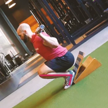 A person doing cyclist squats at home