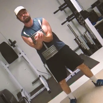 A person doing dumbbell front squats at a home gym