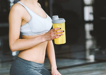 A person drinking protein shake at the gym