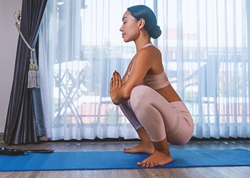 A person doing a frog pose at a home gym