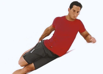 A person doing lying side quad stretches on the ground