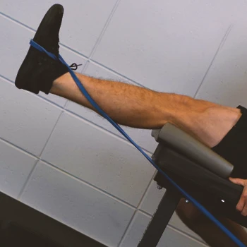 A person doing a seated banded leg extension workout