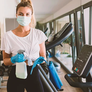 A person spraying lubricant on a treadmill