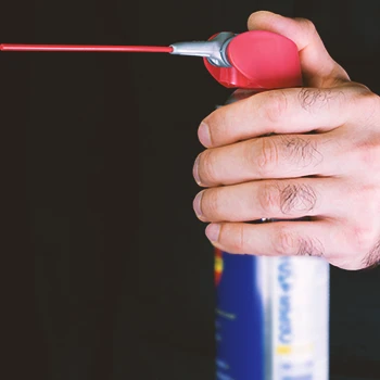 A person holding a spray lube