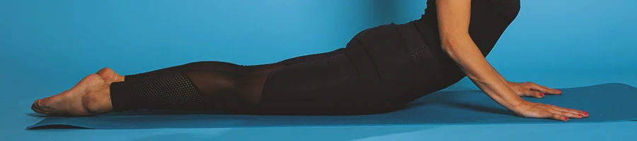 A person on a yoga mat doing quad stretches