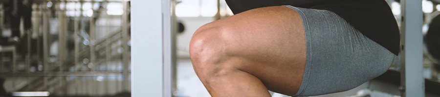 A close up shot of a person's leg muscles in the gym