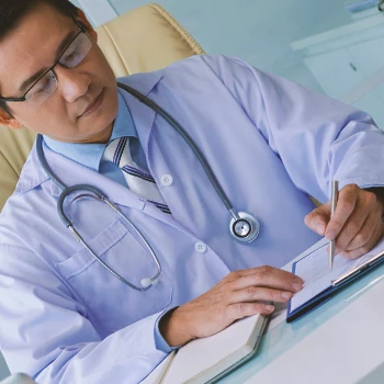 A doctor checking notes on TRT on a clipboard