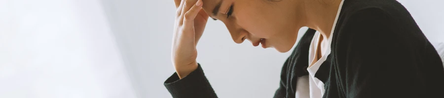 A woman with a headache holding her forehead