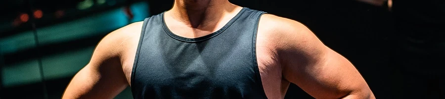 A man in black tank top showing his shoulder muscles