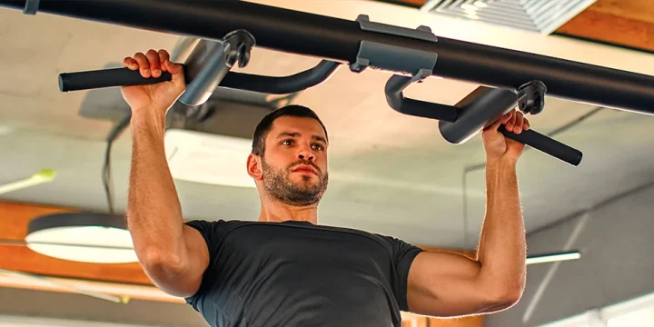 A person working out with a pull up bar using bodyweight at a home gym