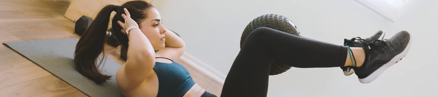 A person doing glute ham raise workout alternatives at a home gym