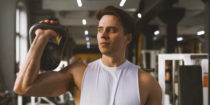 A person at the gym holding a kettlebell