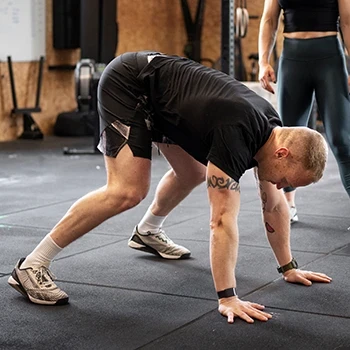 A man doing burpees into tuck jump