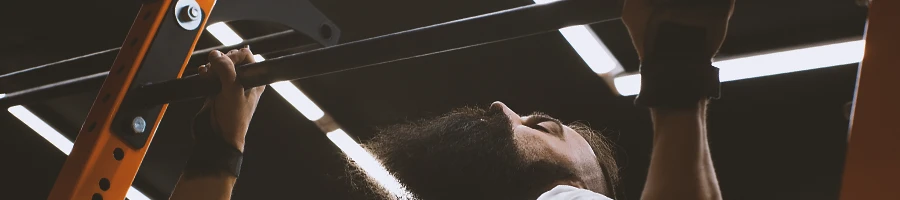 A person doing dead hang variations at the gym