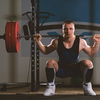 An olympic lifter doing pause squats at the gym