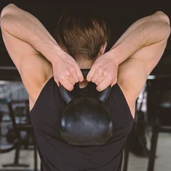 A person working out with a kettlebell behind his back