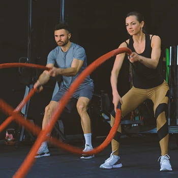 A couple working out with battle ropes