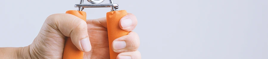 A person holding a hand grip strengthener