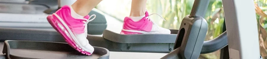 A close up shot of a woman using a stair stepper