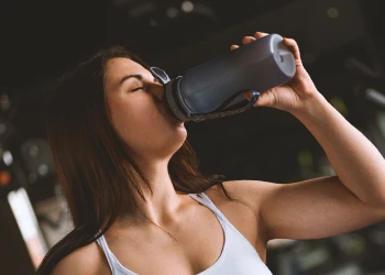 A woman drinking at the gym