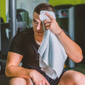A person wiping his sweat at the gym
