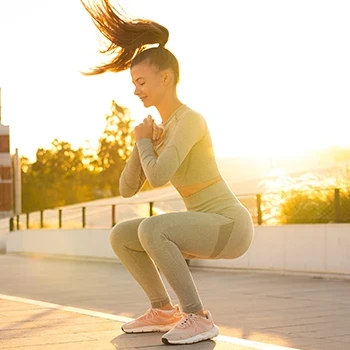 A woman doing jump squats outdoors