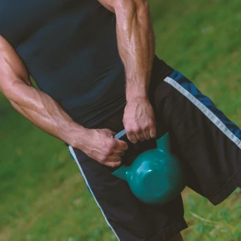 A person doing a kettlebell swing outside