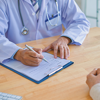 A doctor writing down on a clipboard