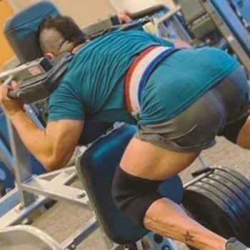 A person at gym doing reverse hack squats